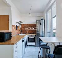 A kitchen with a built-in oven and hob, a floor with a wooden decor, a three-room apartment.