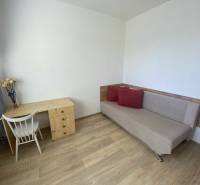 Living room in a 4-room apartment with a table, chair, and sofa. Floor with wood decor.