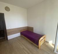 A bedroom with light furniture, a single bed, and a floor with a wooden decor in a 4-room apartment.