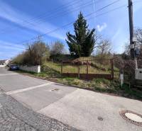 Building plot on Budovateľská Street in Marianka with a gate and access road.