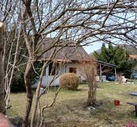 A family house in Vrícko, surrounded by trees and a lawn in the countryside.