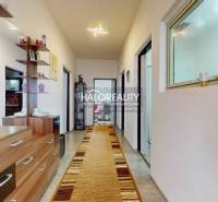 Interior of a family house with a long hallway, wooden decor flooring, and wooden furniture.
