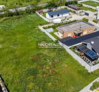 A view of grassy residential plots in Senec, surrounded by family houses.