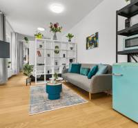 Living area in a studio apartment with wood-patterned flooring and decorations.