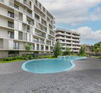 The residential area at Polianky in Bratislava-Dúbravka includes a swimming pool and modern architecture of the apartment building.