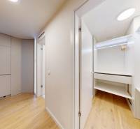 Interior of a 1-room apartment with a wooden decor floor and built-in wardrobes.