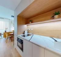 A kitchen with a white marble countertop and a wooden decor floor in a studio apartment.