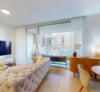 Living room in a one-bedroom apartment with wood-patterned flooring and a balcony.