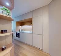 A kitchen in a one-room apartment with white cabinets and wooden decor.