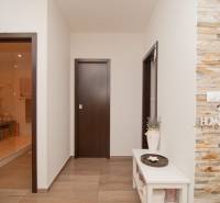 A hallway with stone cladding and a wooden decor floor in a 2-room apartment.