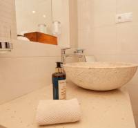 A natural stone sink in the bathroom of a two-room apartment with accessories.