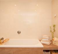 Bathroom with a bathtub, towels, bamboo decoration in a 2-room apartment.