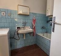 A bathroom in a family house with blue tiles and a bathtub.