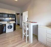 A kitchen in a 3-room apartment with a dining table and a wooden decor floor.