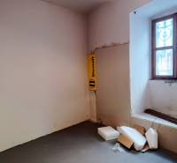 A space with plastics and boxes, with a window with bars, in commercial premises.