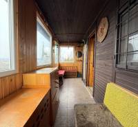 A cottage with wooden decor, cozy furniture, and large windows for a view of nature.