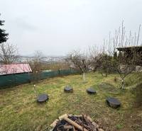 A garden by the cottage in Žilina with a view of the city and trees.