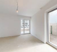 A spacious room in a family house with windows and a concrete floor, bright walls.
