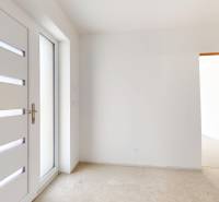 Entrance door with glazing in the interior of a family house with white walls.
