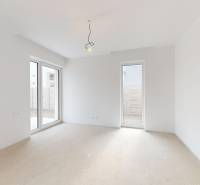 A spacious room in a family house with large windows and white walls.