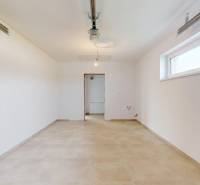 A spacious room with light walls and a window in a family house, flooring with a decor.