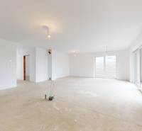 Interior of a family house with white walls and large windows, floor ready for finishing.