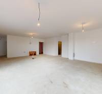 A spacious room in a family house with an incomplete floor and large windows.