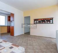 The interior of a family house with a tiled floor, a painting of elephants, and a view into the kitchen.