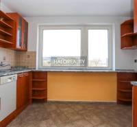 A kitchen in a family house with a kitchen unit and a large window, tiled floor.