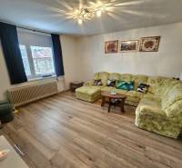 Living room in a family house with a sofa, armchairs, and a wooden decor floor.
