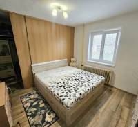 Bedroom with a bed and wooden decor flooring in a family house.