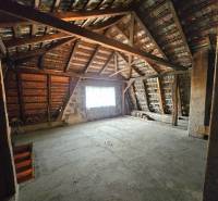 The attic of a family house with exposed roof structure and staircase.