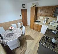 A kitchen in a family house with wooden decor and a dining table.