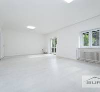 Spacious living room in a 4-room apartment with white flooring and large windows.