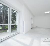 A bright room with large windows and a wooden decor floor in a 4-room apartment.