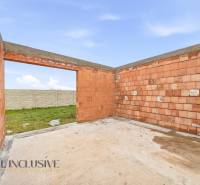 Unfinished construction of a family house in Veľké Dvorníky with a door opening and a garden.