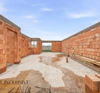 Construction of a family house in Veľké Dvorníky with brick walls and a concrete foundation.