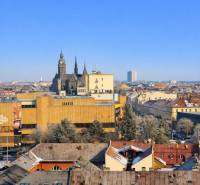 A view of the historical center of Košice, towers and buildings, with a blue sky in the background.