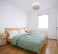 Bedroom in a 3-room apartment with a bed, nightstands, and a floor with a wooden decor.