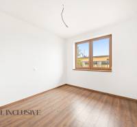 A room in a family house with a wooden decor floor and a large window.