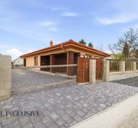A family house in Horné Mýto with a brick decor, a paved driveway, and a landscaped yard.