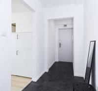 A hallway with a dark floor and white walls in a 2-room apartment.