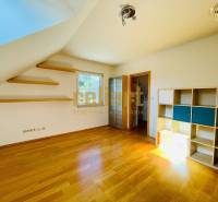 A room in a family house with a wooden decor floor, shelves, and a shelving cabinet.
