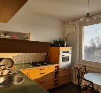 A kitchen with a gas stove, a window, and a table in a 3-room apartment.