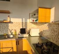 A kitchen in a 3-room apartment with wooden cabinets and mosaic tiles.