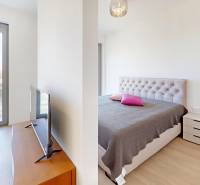 Double bedroom in a two-room apartment with wood-patterned flooring and a balcony.