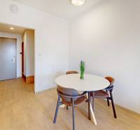 Interior of a 2-room apartment with a dining table and a floor with a wooden decor.