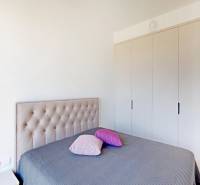Bedroom in a 2-room apartment with a bed and a wardrobe.