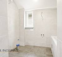A bathroom in a family house with large-format light tiles.