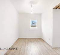 A room in a family house with white walls and a wooden decor floor.